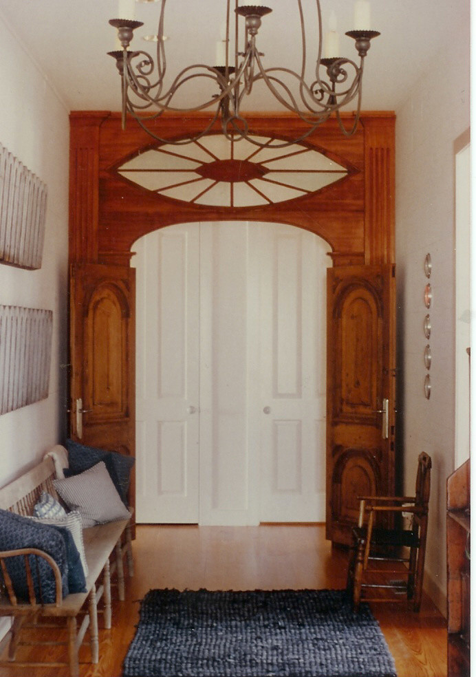 Example of a large classic medium tone wood floor foyer design in Other with white walls