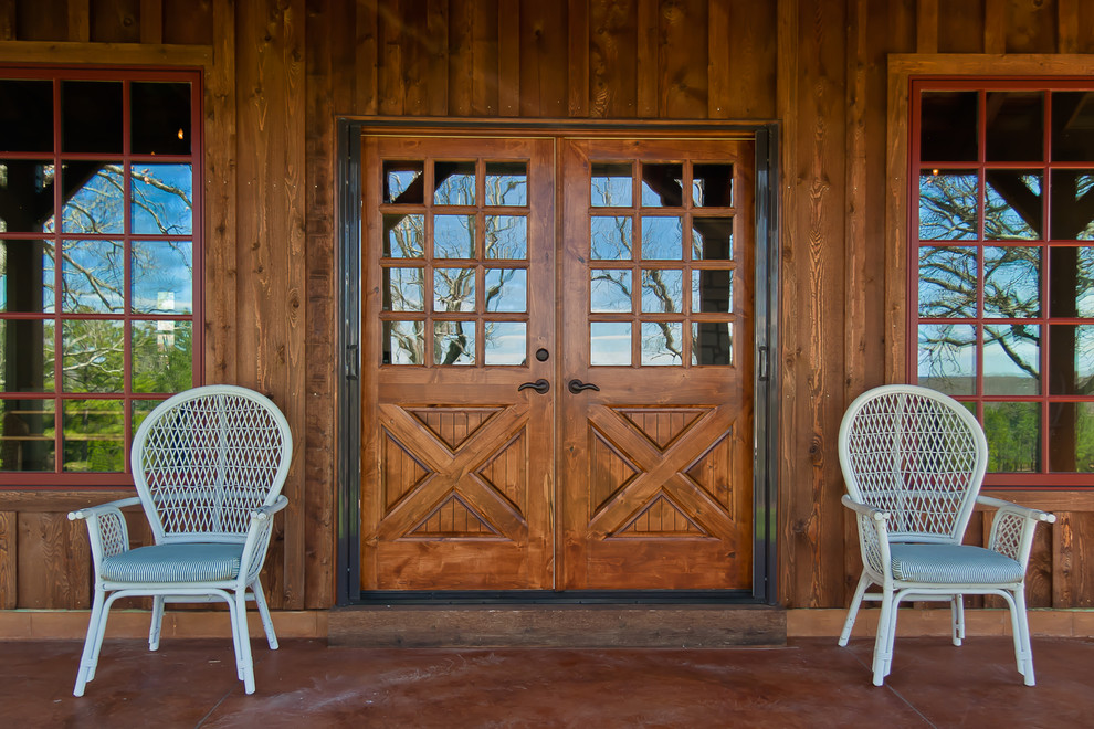 Imagen de entrada rural con puerta doble, puerta de madera en tonos medios y suelo rojo
