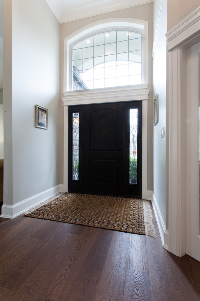 Idee per una porta d'ingresso tradizionale di medie dimensioni con pareti grigie, pavimento in legno massello medio, una porta singola e una porta nera