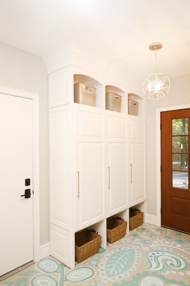 Cette photo montre une entrée chic de taille moyenne avec un vestiaire, un mur blanc, sol en béton ciré et une porte simple.