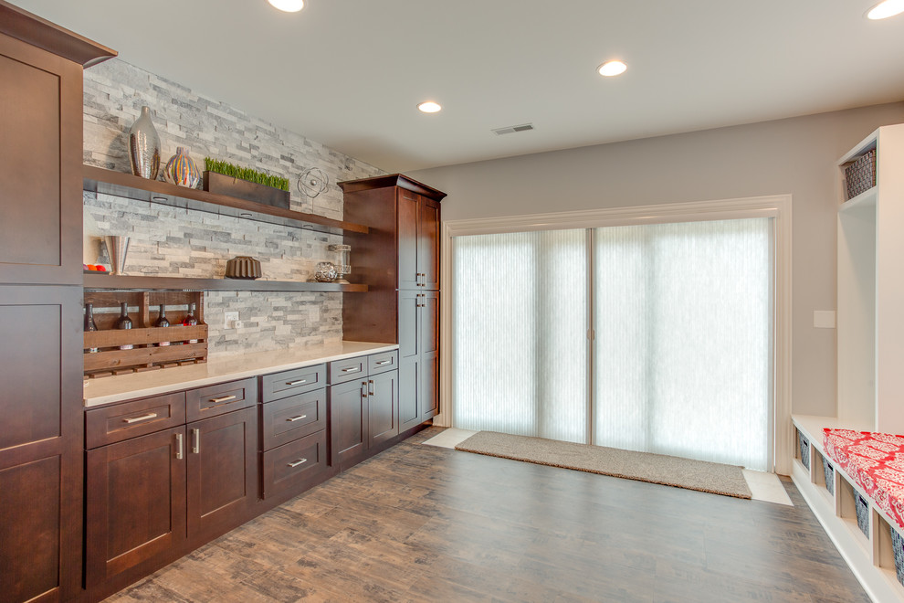 This is an example of a medium sized traditional boot room in Chicago with grey walls, laminate floors, a glass front door and brown floors.