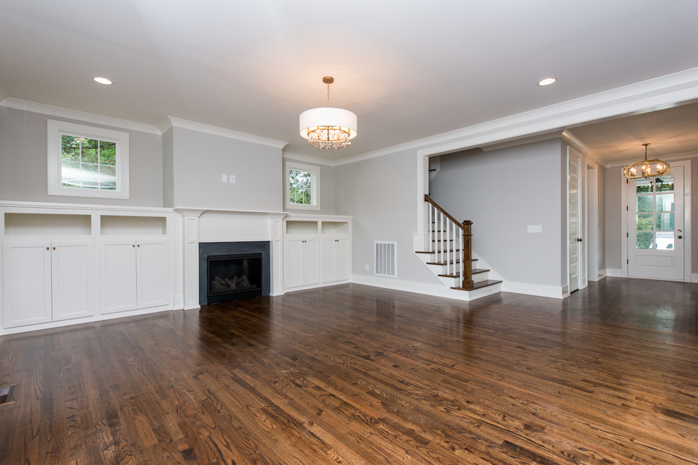 Example of a large classic medium tone wood floor entryway design in Raleigh with gray walls and a white front door