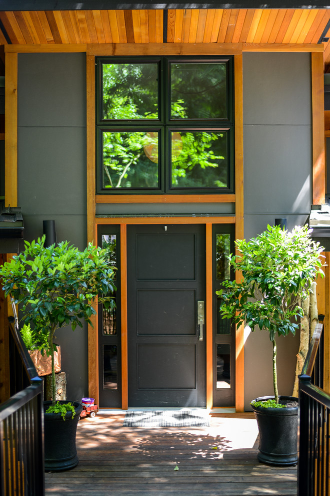 Exempel på en modern ingång och ytterdörr, med grå väggar, mörkt trägolv, en enkeldörr, en svart dörr och flerfärgat golv