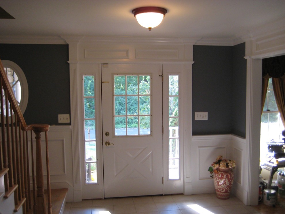 Esempio di un ingresso classico di medie dimensioni con pareti gialle, pavimento in legno massello medio, una porta singola, una porta in legno scuro e pavimento marrone