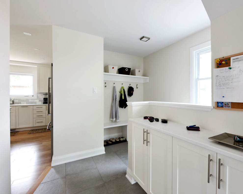 This is an example of a medium sized classic boot room in Ottawa with white walls, porcelain flooring and grey floors.