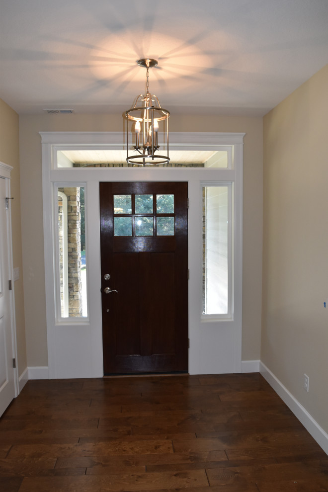 Cette photo montre une entrée craftsman de taille moyenne avec un mur gris, parquet foncé, une porte simple, une porte en bois brun et un sol vert.