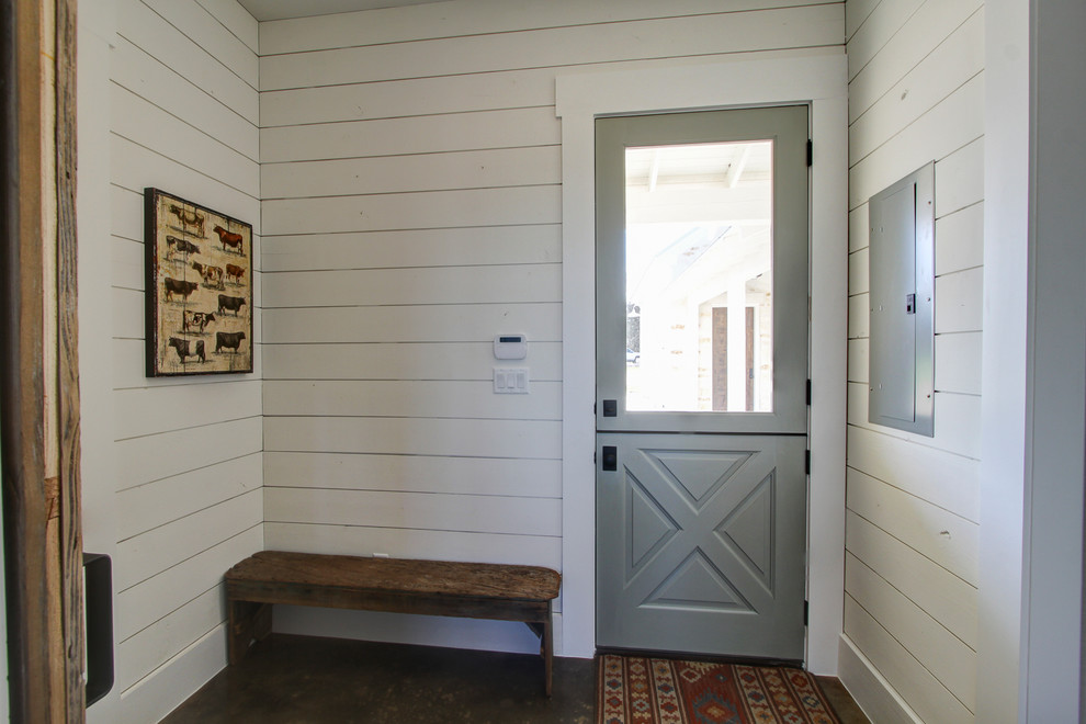 Entryway - cottage concrete floor entryway idea in Austin with white walls and a gray front door