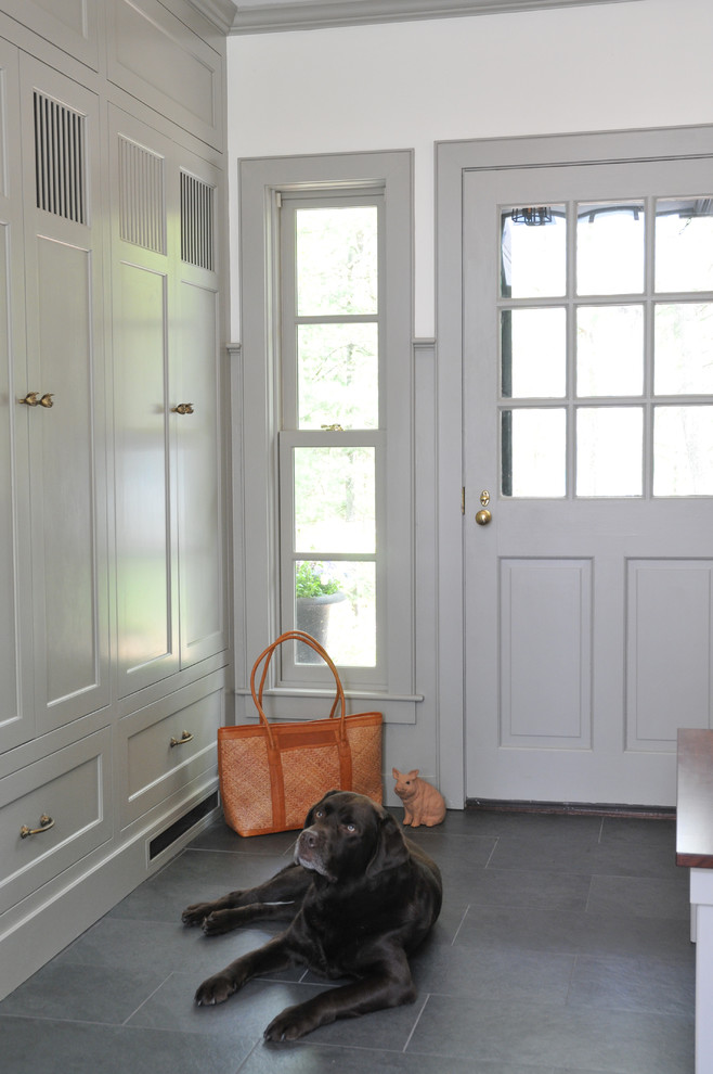 На фото: тамбур среднего размера в стиле неоклассика (современная классика) с бежевыми стенами, полом из сланца, одностворчатой входной дверью, серой входной дверью и черным полом