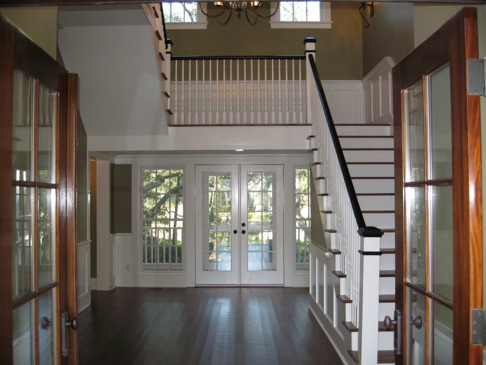 Exemple d'un hall d'entrée nature avec un mur gris, parquet foncé, une porte double et une porte en bois brun.