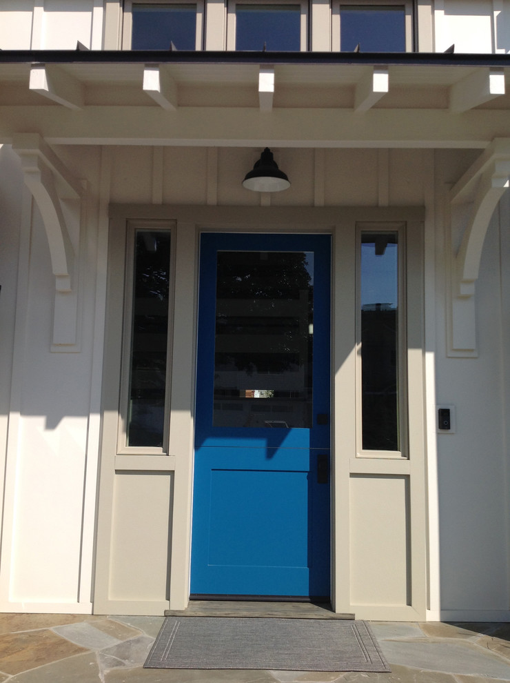Lantlig inredning av en mellanstor ingång och ytterdörr, med vita väggar, en tvådelad stalldörr och en blå dörr