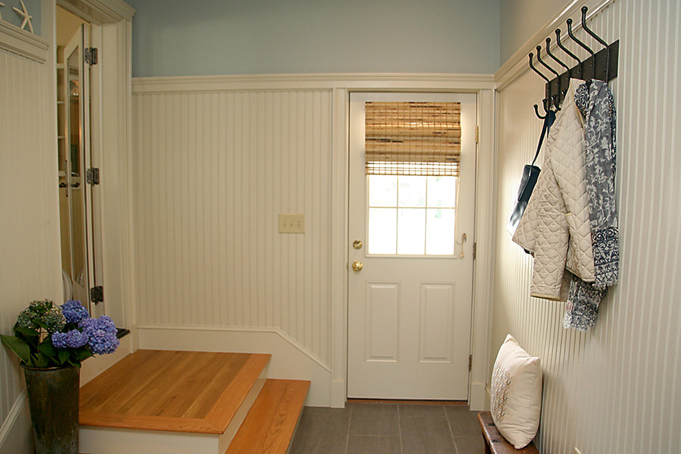 Cette photo montre une entrée nature de taille moyenne avec un vestiaire, un mur bleu, un sol en carrelage de céramique, une porte simple et une porte blanche.