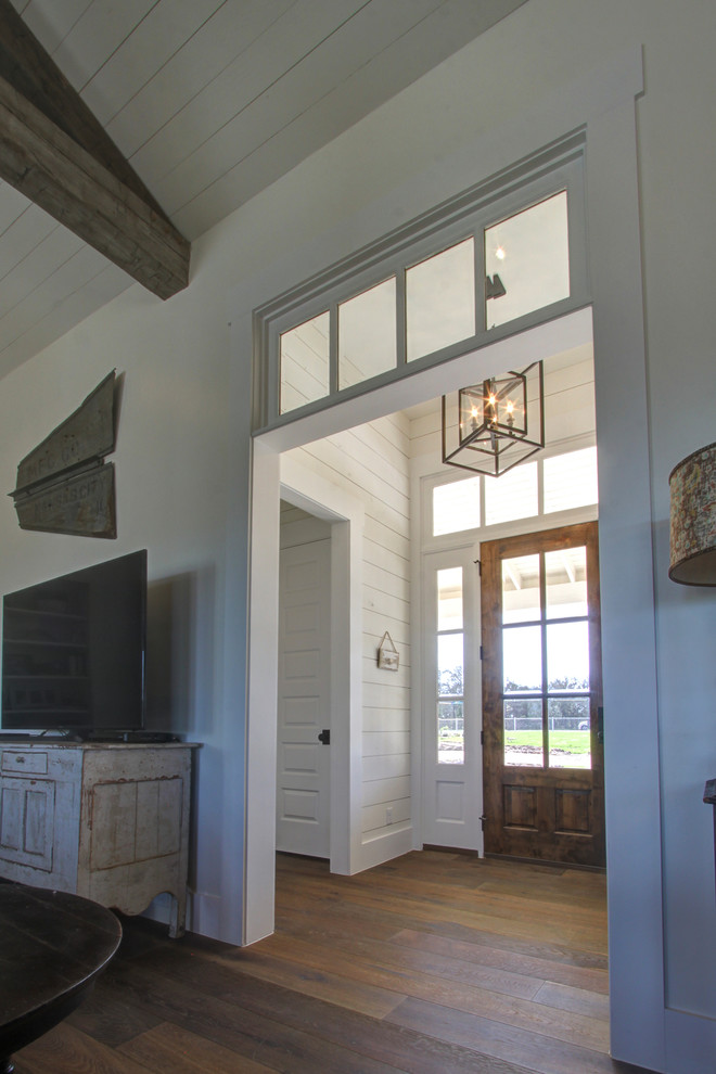 Пример оригинального дизайна: фойе среднего размера в стиле кантри с белыми стенами, паркетным полом среднего тона, одностворчатой входной дверью, входной дверью из дерева среднего тона и коричневым полом