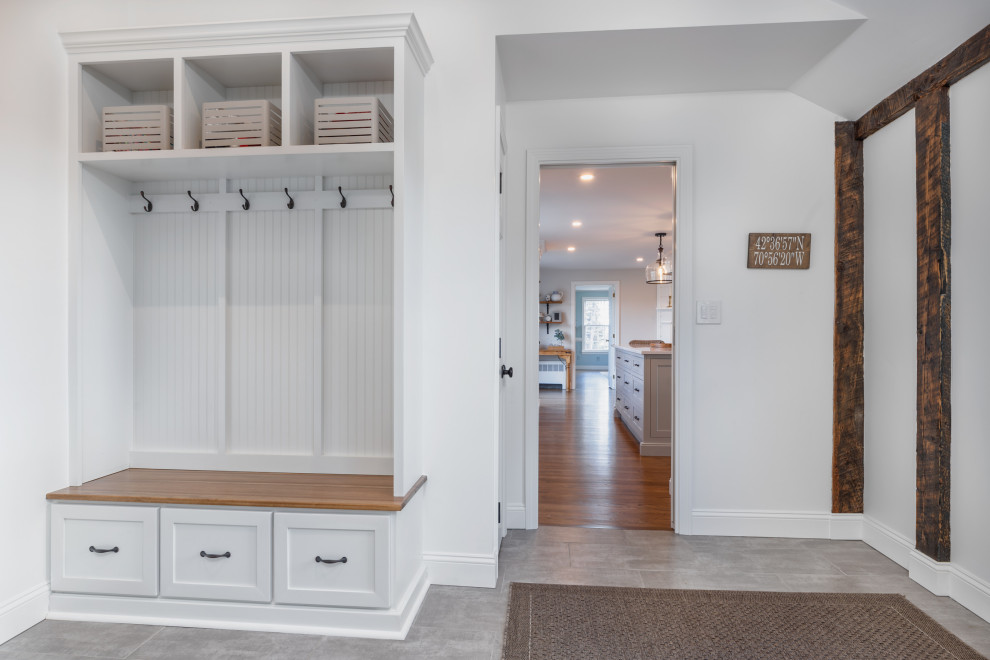 This is an example of a medium sized farmhouse boot room in Boston with grey walls, porcelain flooring, a single front door, a white front door and grey floors.