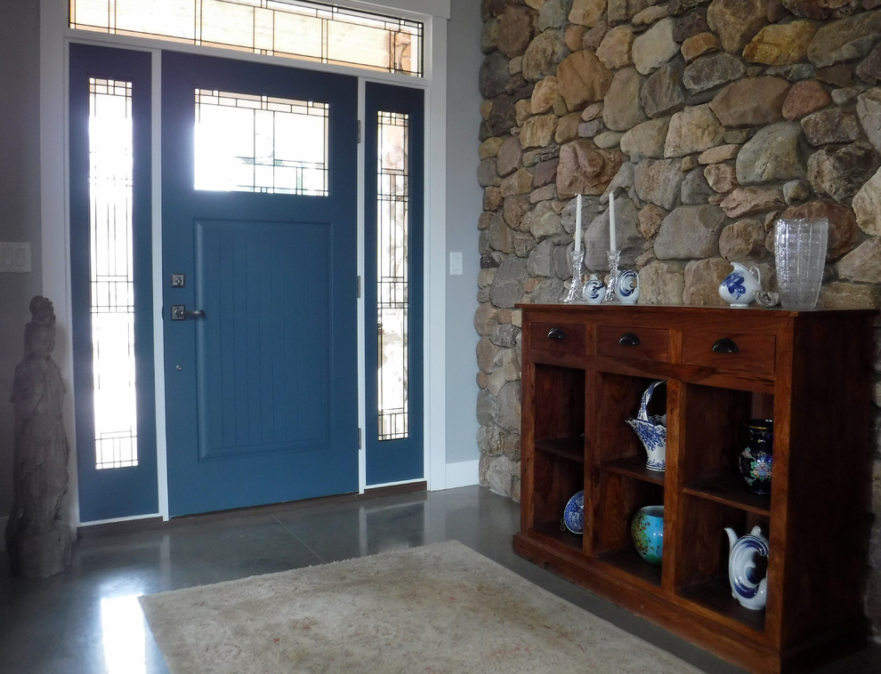 This is an example of a medium sized rural foyer in Salt Lake City with grey walls, concrete flooring, a single front door and a blue front door.