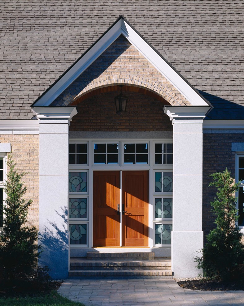 Immagine di una porta d'ingresso country con una porta a due ante e una porta in legno bruno