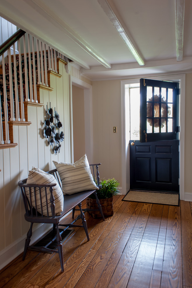 Inspiration for a large cottage medium tone wood floor entryway remodel in Philadelphia with beige walls and a black front door