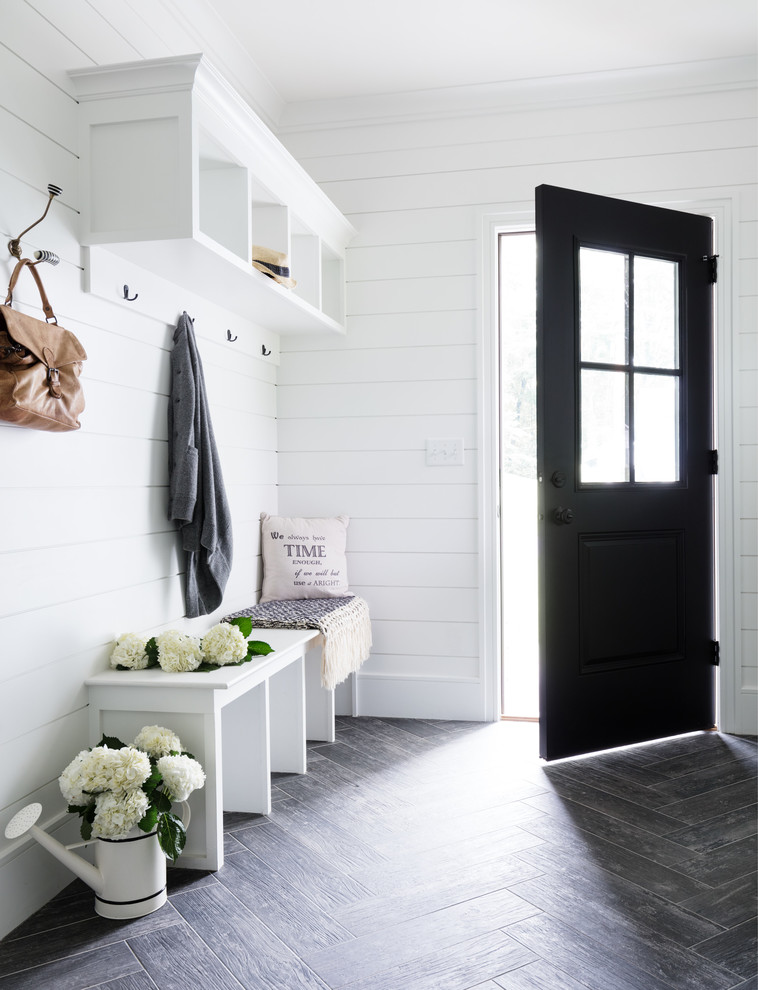 Photo of a rural boot room in New York with white walls, a single front door and a black front door.