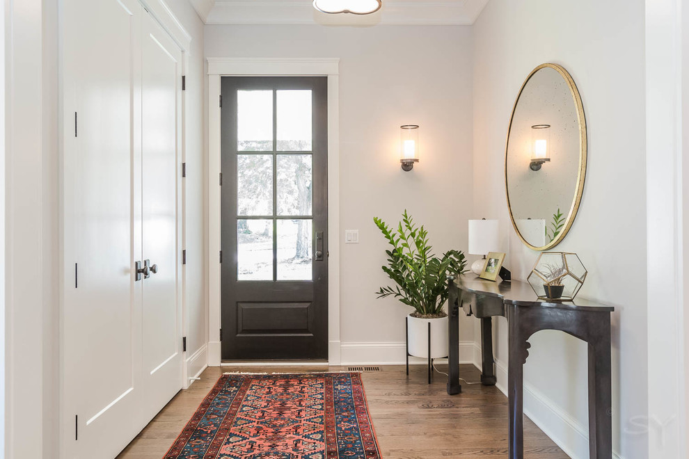 Inspiration for a mid-sized country medium tone wood floor and brown floor entryway remodel in Chicago with white walls and a black front door