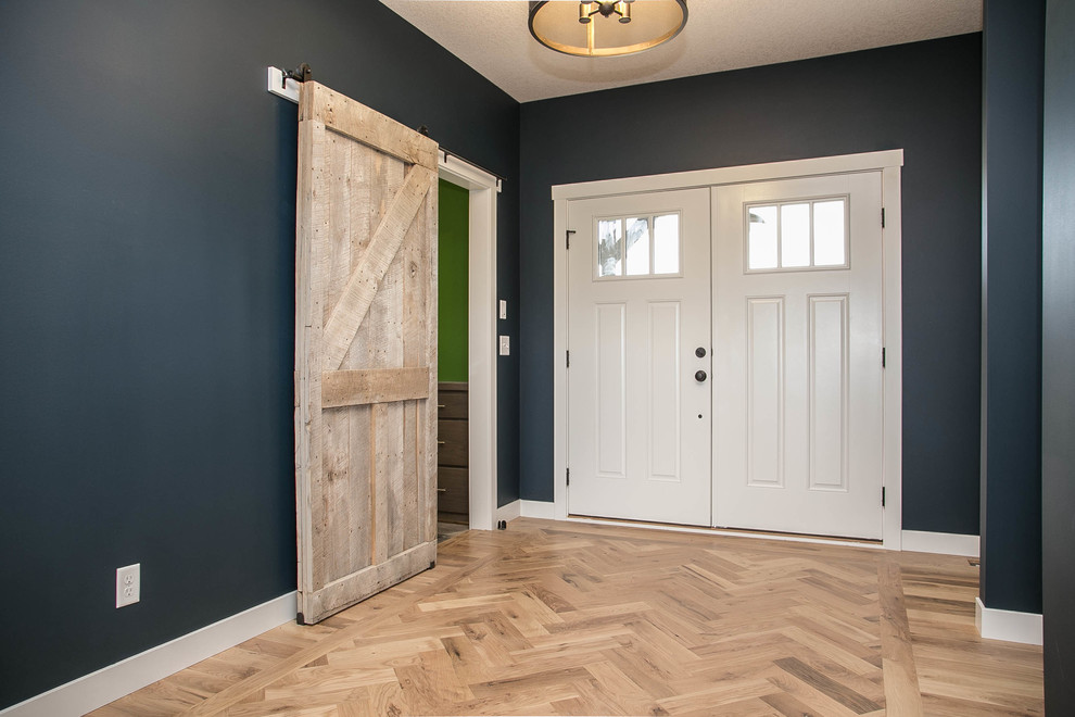 Entryway - cottage light wood floor entryway idea in Minneapolis with gray walls and a white front door