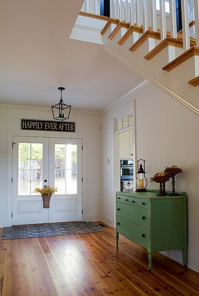 Foto de distribuidor de estilo de casa de campo de tamaño medio con paredes blancas, suelo de madera en tonos medios, puerta doble, puerta blanca y suelo marrón