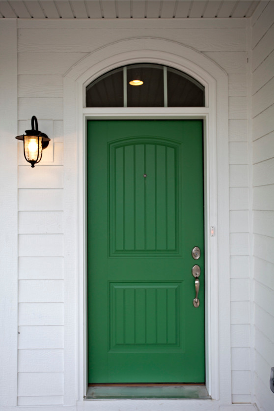 Idée de décoration pour une grande porte d'entrée champêtre avec une porte simple et une porte verte.