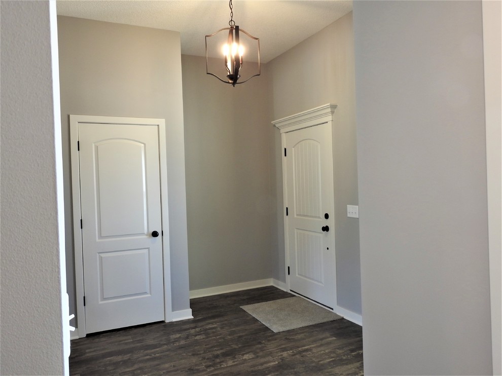 Large farmhouse foyer in Other with grey walls, laminate floors, a single front door, a white front door and brown floors.