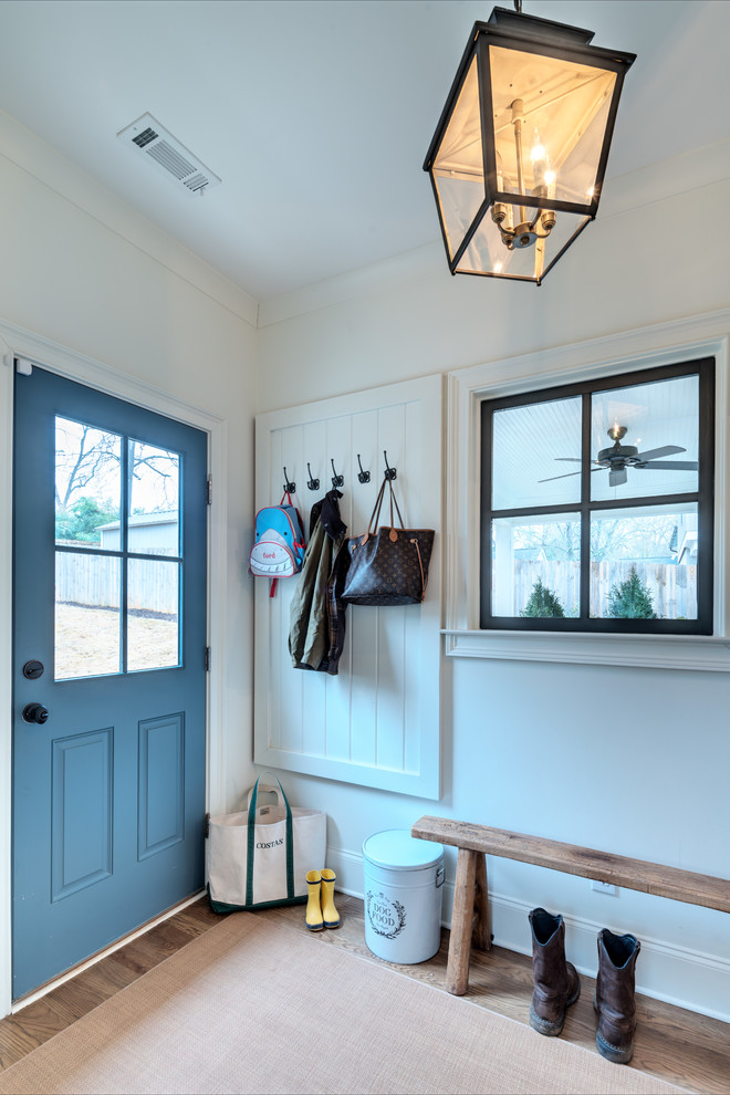 Exempel på ett lantligt kapprum, med vita väggar, mellanmörkt trägolv, en enkeldörr, en blå dörr och brunt golv