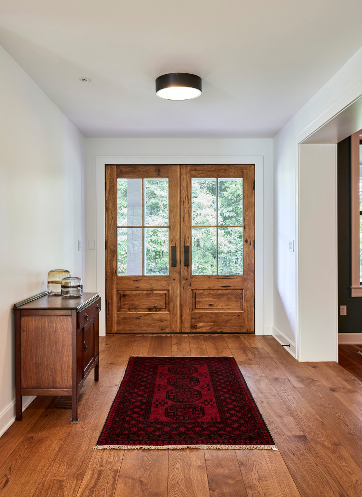 Mid-sized farmhouse medium tone wood floor entryway photo in Cincinnati with white walls and a medium wood front door
