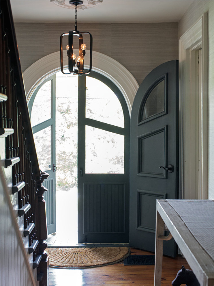 Réalisation d'une porte d'entrée champêtre de taille moyenne avec un mur bleu, un sol en bois brun, une porte double et une porte bleue.