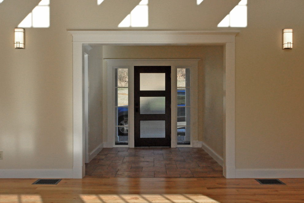 Entryway - mid-sized country travertine floor entryway idea in Cincinnati with beige walls and a dark wood front door