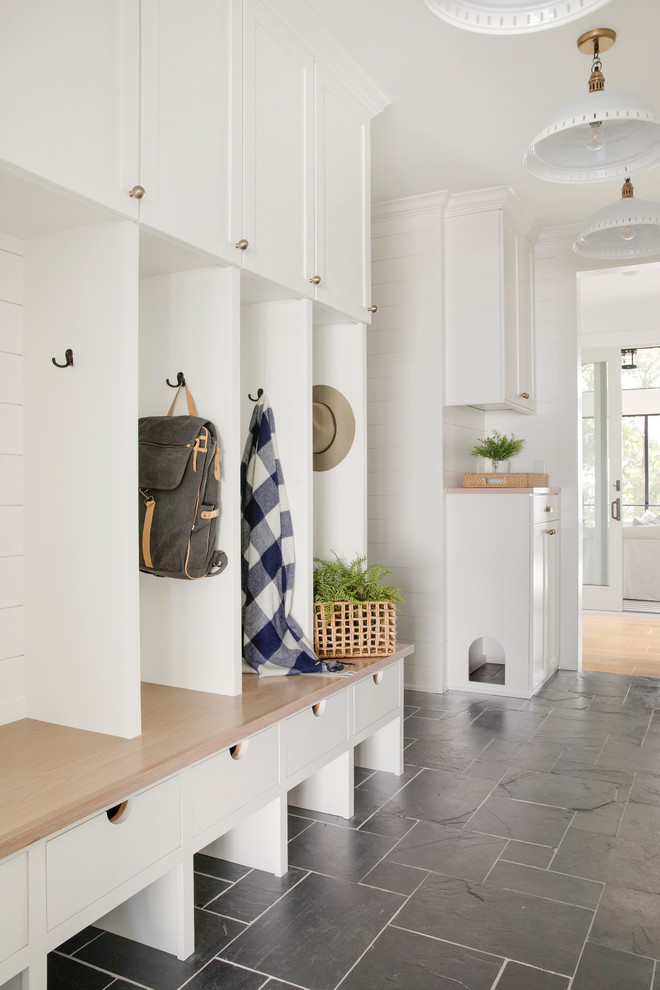 Inspiration for a country black floor mudroom remodel in Minneapolis with white walls