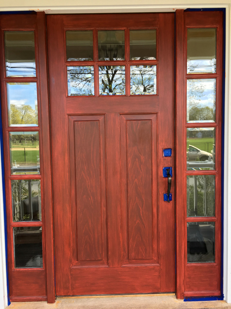 Réalisation d'une petite porte d'entrée tradition avec un mur gris, une porte pivot et une porte en bois brun.