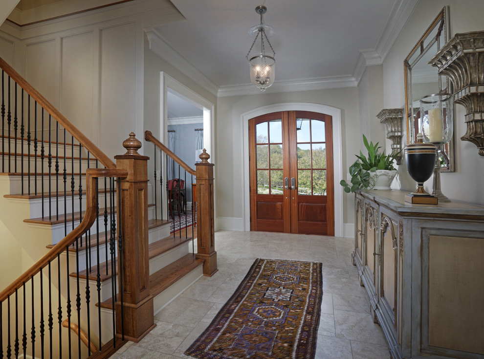 Immagine di un ingresso classico di medie dimensioni con pareti beige, pavimento in travertino, una porta a due ante e una porta in legno bruno