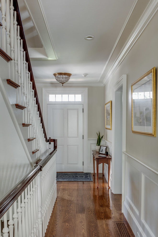 Kleines Klassisches Foyer mit weißer Wandfarbe, braunem Holzboden, Einzeltür, weißer Haustür und braunem Boden in Boston