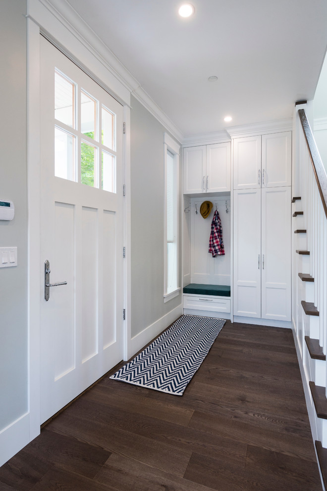 Kleine Klassische Haustür mit grauer Wandfarbe, dunklem Holzboden, Einzeltür, weißer Haustür und braunem Boden in Vancouver