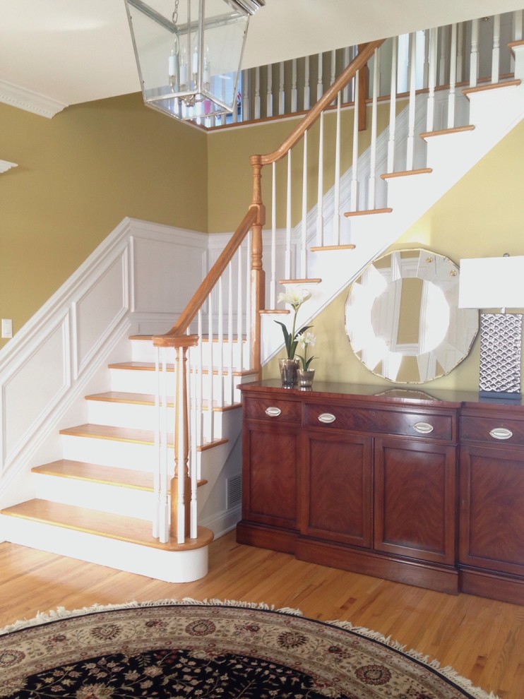This is an example of a medium sized classic foyer in New York with yellow walls and light hardwood flooring.