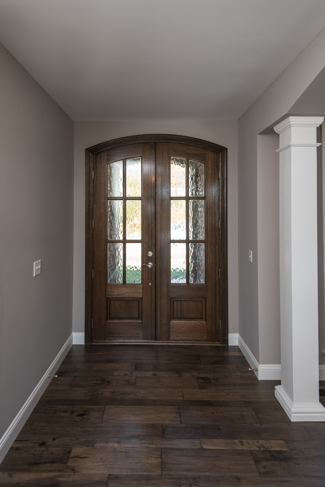 Idées déco pour un hall d'entrée classique de taille moyenne avec un mur beige, un sol en bois brun, une porte double et une porte en bois brun.