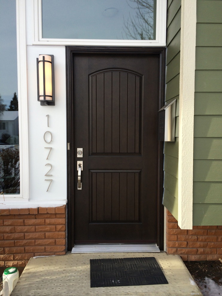 Immagine di una porta d'ingresso american style di medie dimensioni con una porta singola, pareti verdi e una porta in legno scuro