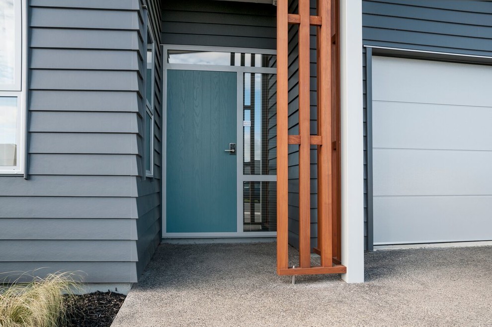 Ispirazione per una porta d'ingresso minimalista con pareti multicolore, una porta singola e una porta grigia