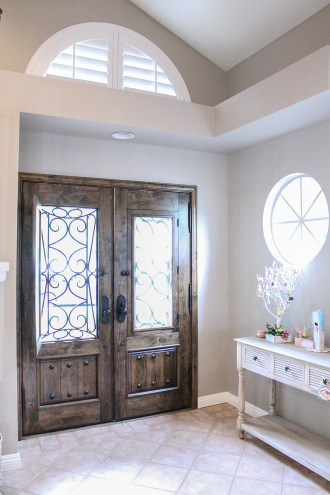 На фото: входная дверь среднего размера в стиле шебби-шик с серыми стенами, полом из травертина, одностворчатой входной дверью и входной дверью из темного дерева