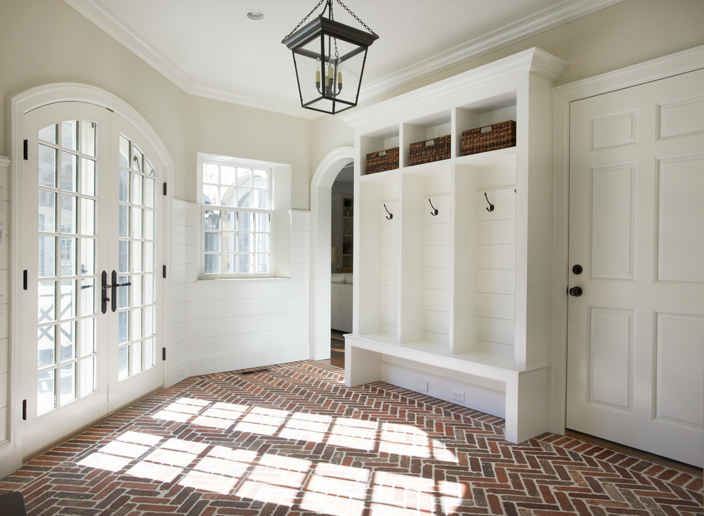 Inspiration för ett vintage kapprum, med beige väggar, tegelgolv, en enkeldörr och en vit dörr