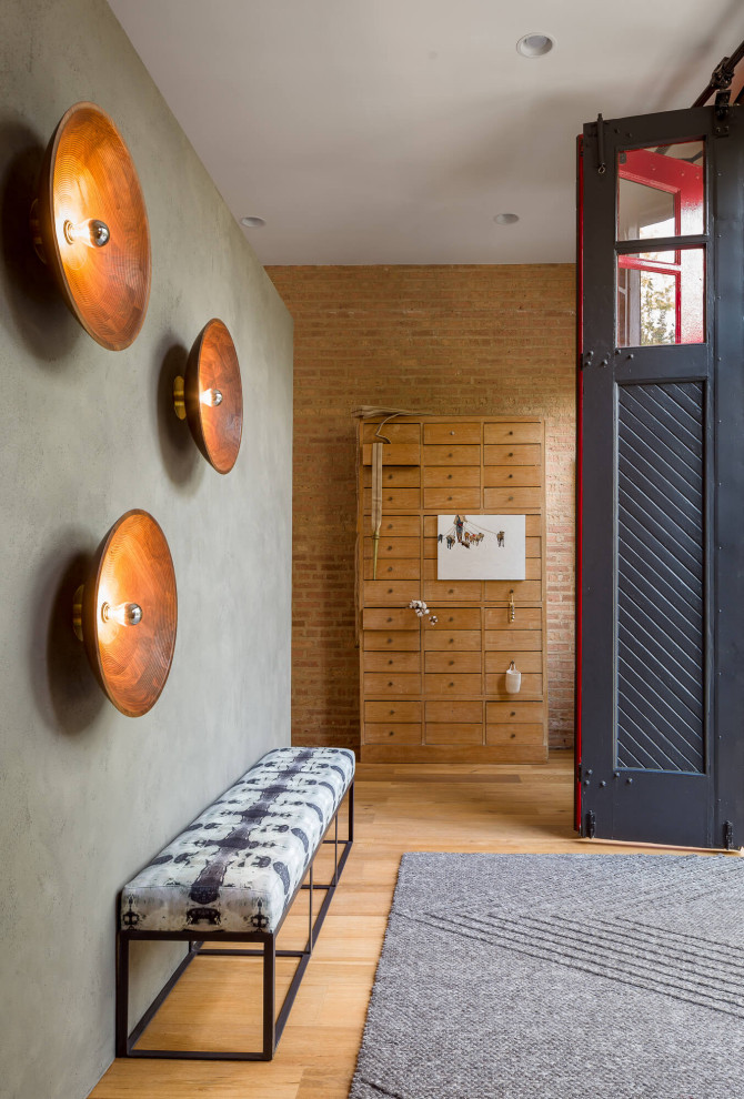 На фото: фойе в стиле неоклассика (современная классика) с серыми стенами, паркетным полом среднего тона, раздвижной входной дверью, черной входной дверью, коричневым полом и кирпичными стенами с