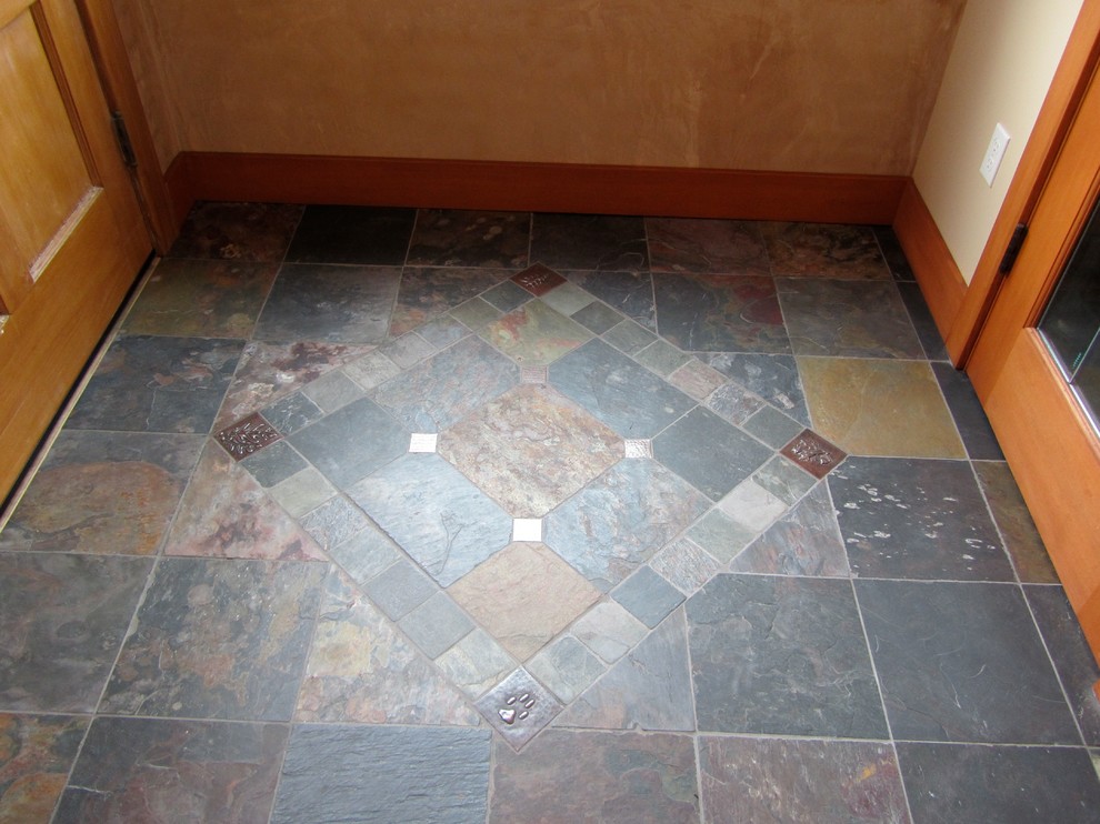Arts and crafts slate floor and blue floor entryway photo in Boise with brown walls and a light wood front door