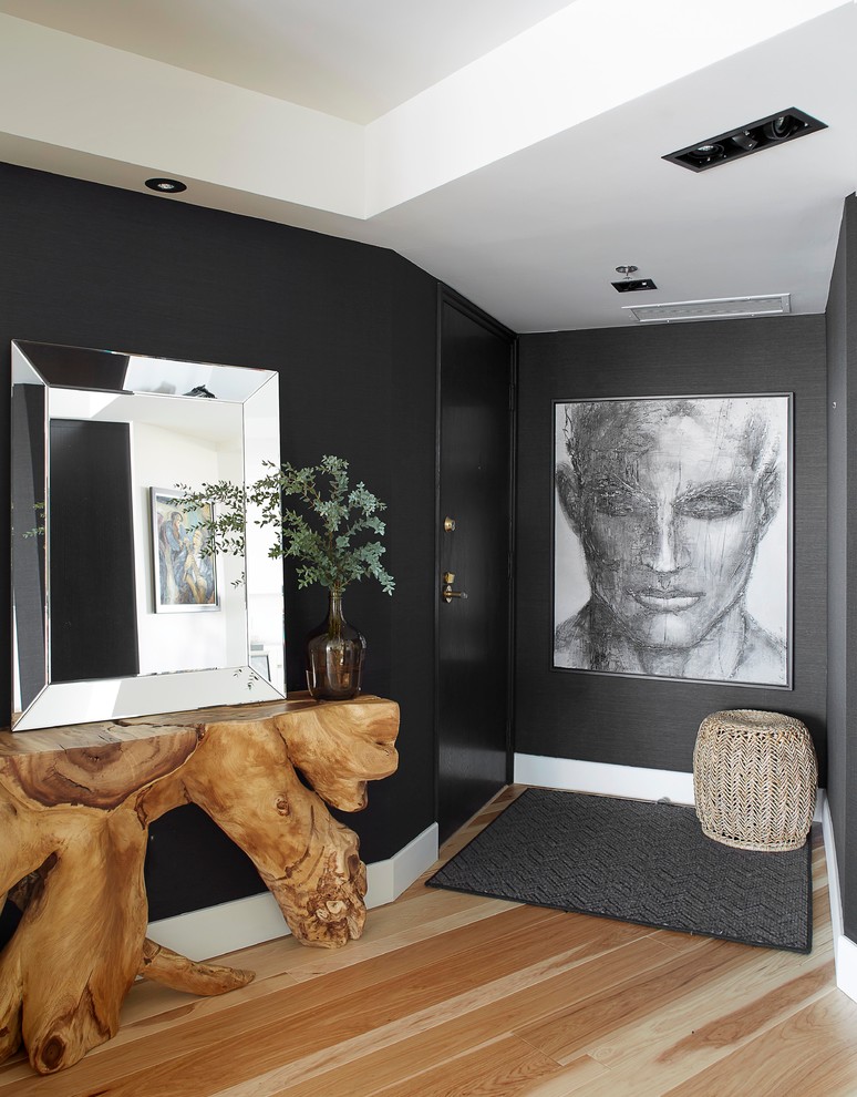 На фото: фойе в современном стиле с черными стенами, светлым паркетным полом и черной входной дверью с