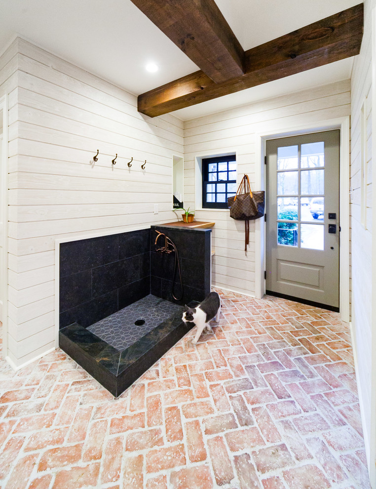 Exempel på ett stort lantligt kapprum, med vita väggar, tegelgolv, en enkeldörr, en grå dörr och flerfärgat golv