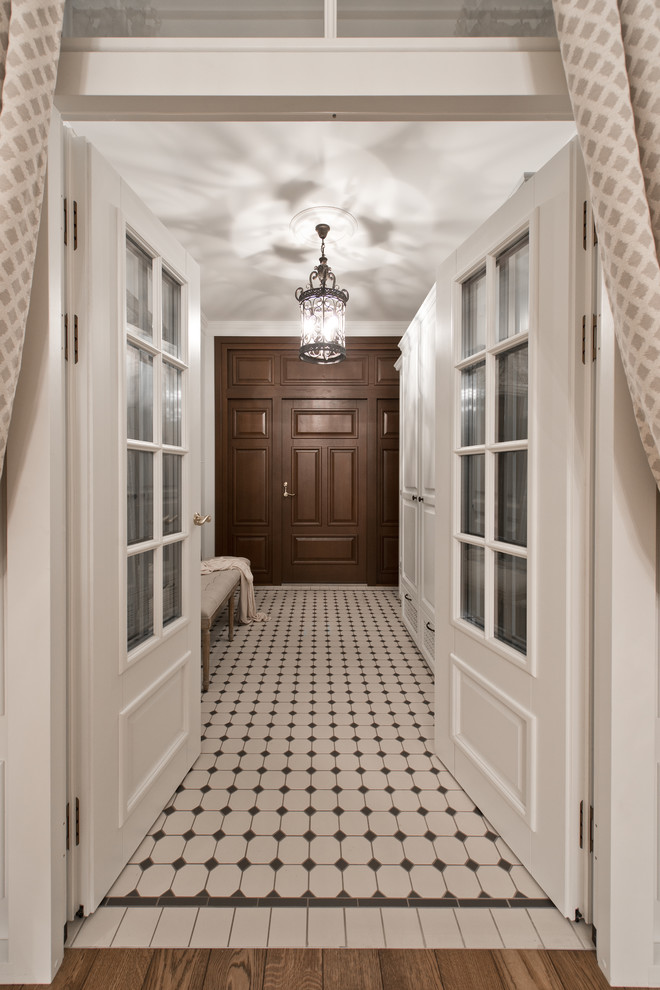 Diseño de puerta principal clásica de tamaño medio con paredes blancas, suelo de madera pintada, puerta doble y puerta de madera oscura