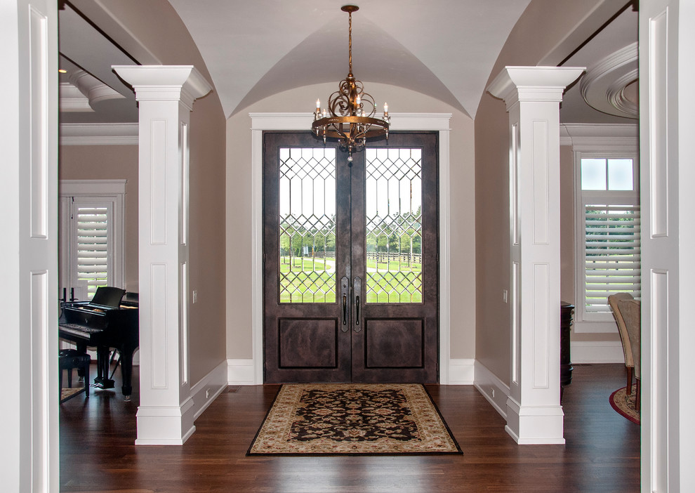 Großes Klassisches Foyer mit beiger Wandfarbe, dunklem Holzboden, Doppeltür und Haustür aus Metall in Sonstige