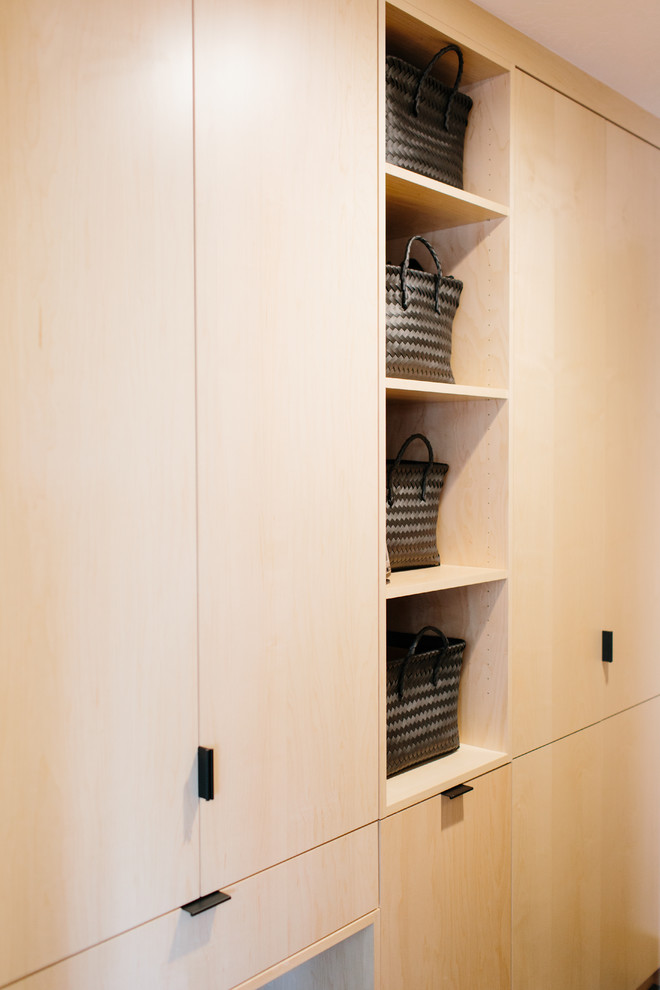 Medium sized contemporary boot room in Seattle with white walls, ceramic flooring, a single front door, a light wood front door and black floors.