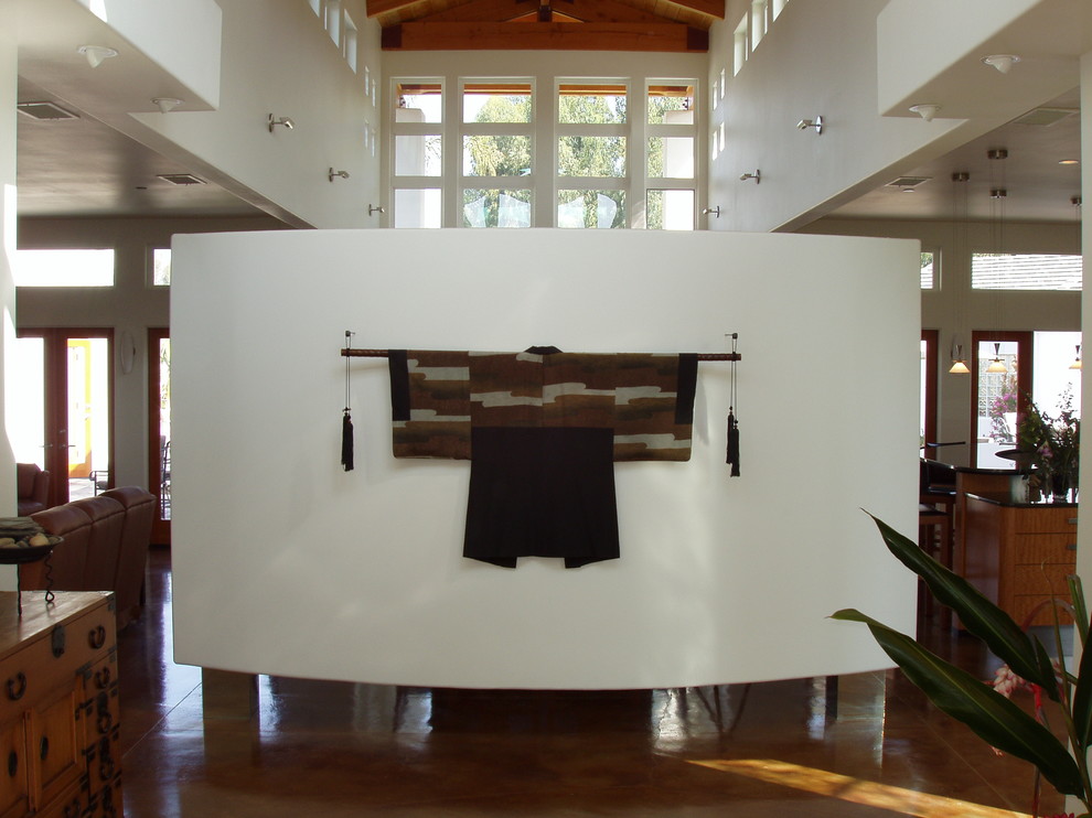 Réalisation d'un hall d'entrée design avec un mur blanc et sol en béton ciré.