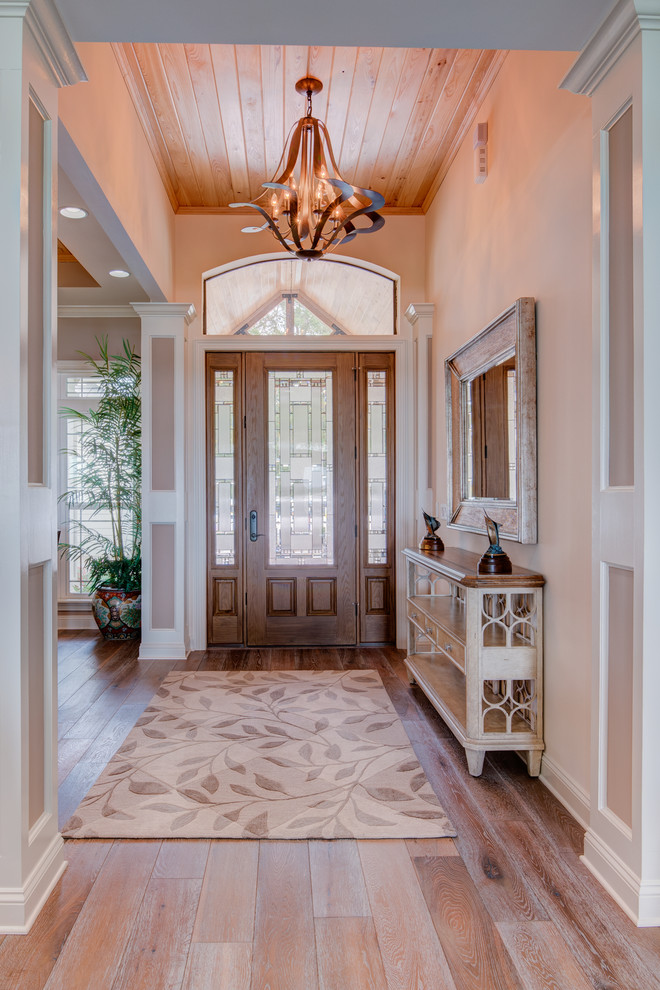 Inspiration for a large beach style front door in Jacksonville with beige walls, light hardwood flooring, a single front door and a medium wood front door.